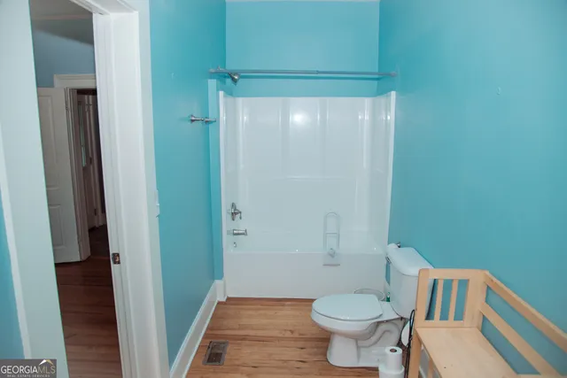 a view of a room with wooden floor and a ceiling fan