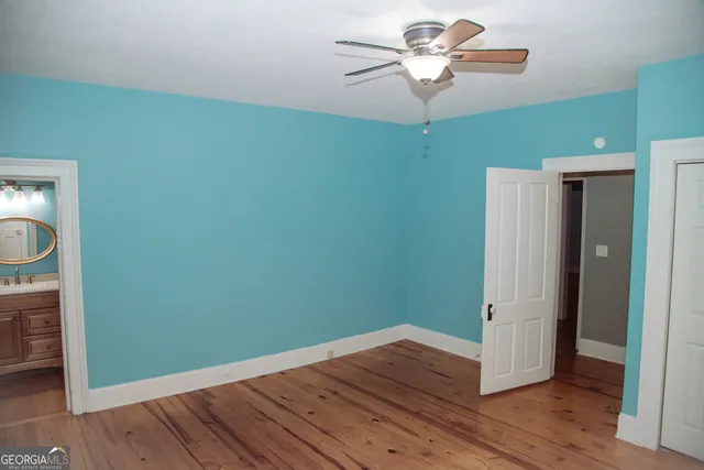 an empty room with wooden floor and closet