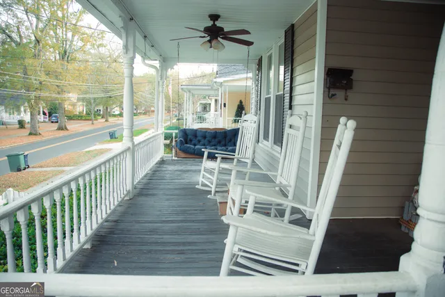 a view of a porch with wooden floor and furniture