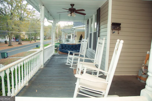 a kitchen with stainless steel appliances a stove top oven a refrigerator a sink and white cabinets with wooden floor