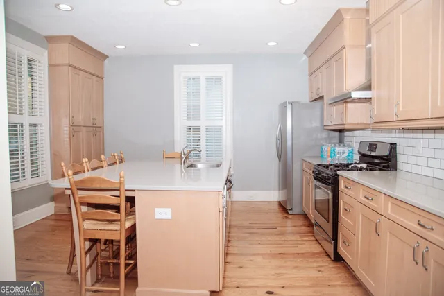 a kitchen with stainless steel appliances a stove a sink and a refrigerator