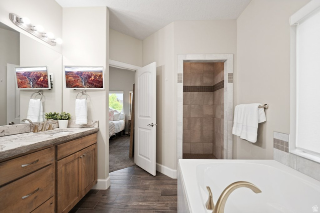 175 West 1000 North Mapleton, UT 84664 - Photo 25 of 42 Bathroom featuring a dual vanity with a stone countertop, a built-in soaking tub with deck-mounted fixtures, and a walk-in shower with tiled walls