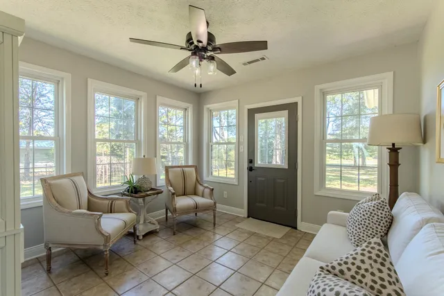 a living room with furniture and two windows