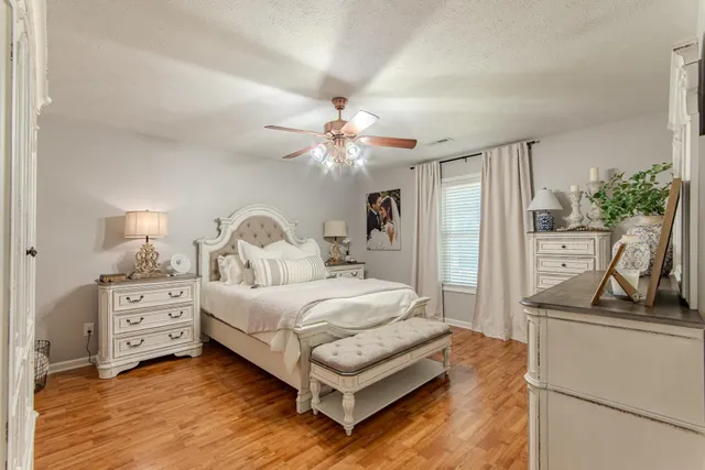 a bedroom with a bed window and a flat screen tv