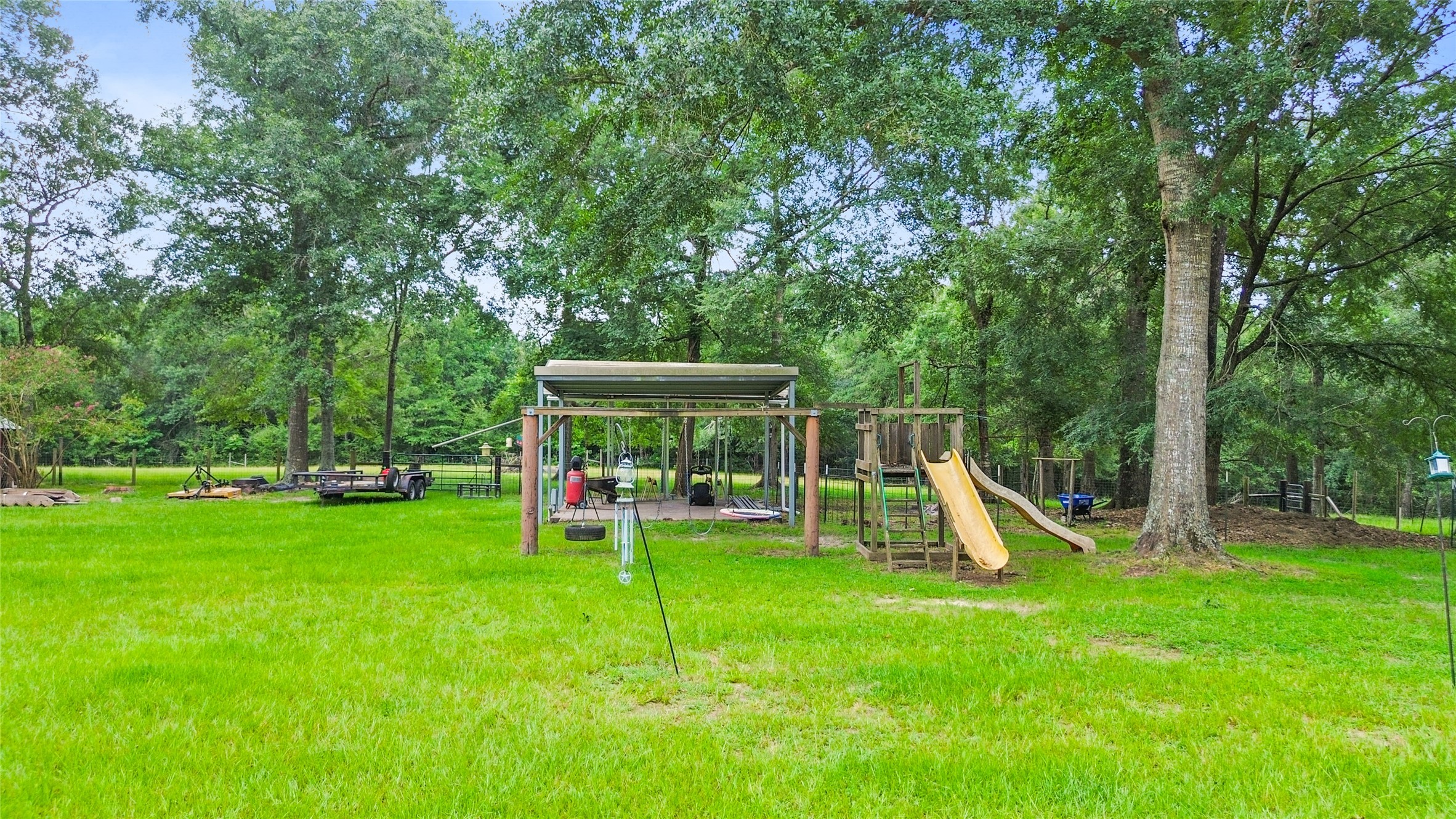11270 Summit Drive Conroe, TX 77303 - Photo 25 of 35 a view of a backyard with a slide and a child swing