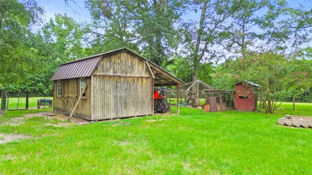 a view of a small house with a big yard and large tree