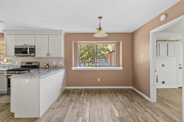 a kitchen with stainless steel appliances granite countertop a stove and a wooden floors