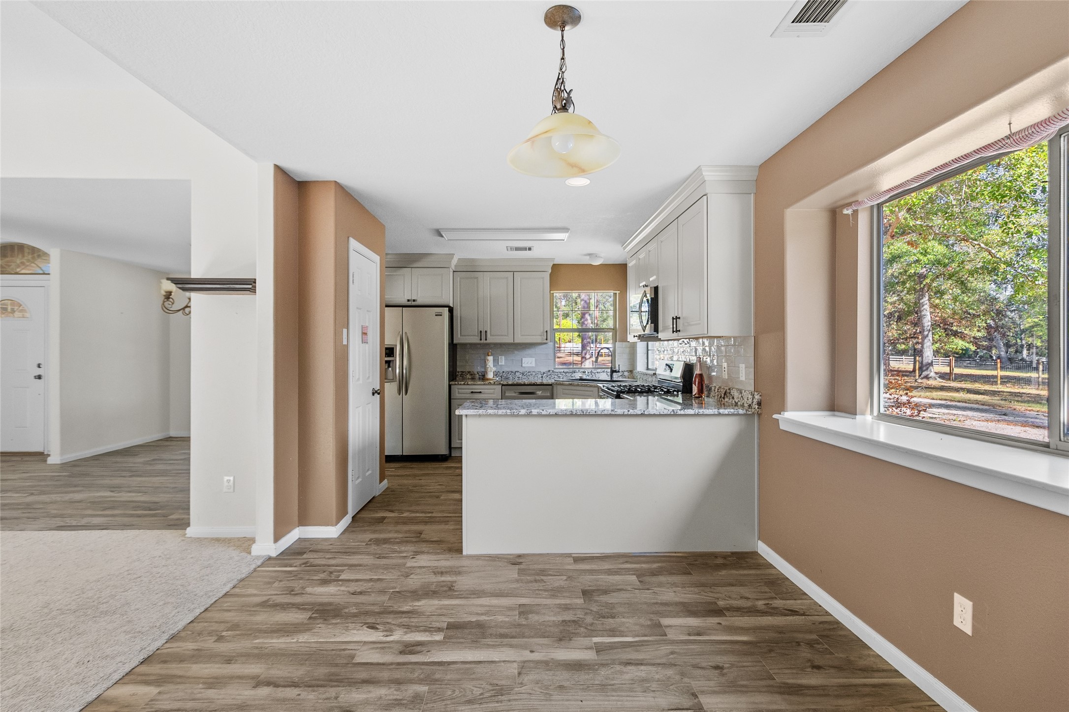 11270 Summit Drive Conroe, TX 77303 - Photo 9 of 35 a view of kitchen with stainless steel appliances granite countertop a refrigerator a sink dishwasher a stove and white countertops with wooden floor