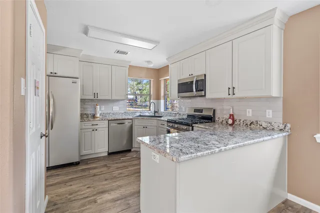 a kitchen with a sink a stove a refrigerator and cabinets