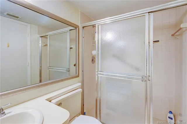 a bathroom with a toilet a sink and glass door