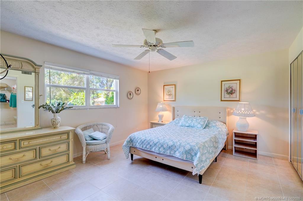 2950 Southeast Ocean Boulevard, Unit 1211 Stuart, FL 34996 - Photo 30 of 61 a bedroom with a bed and a dresser next to a window