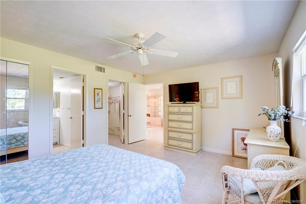 2950 Southeast Ocean Boulevard, Unit 1211 Stuart, FL 34996 - Photo 32 of 61 a bedroom with furniture and a flat screen tv