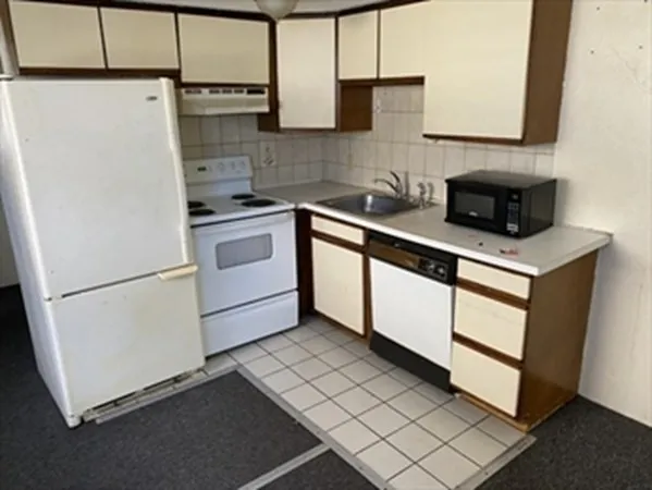 a kitchen with a cabinets and white appliances