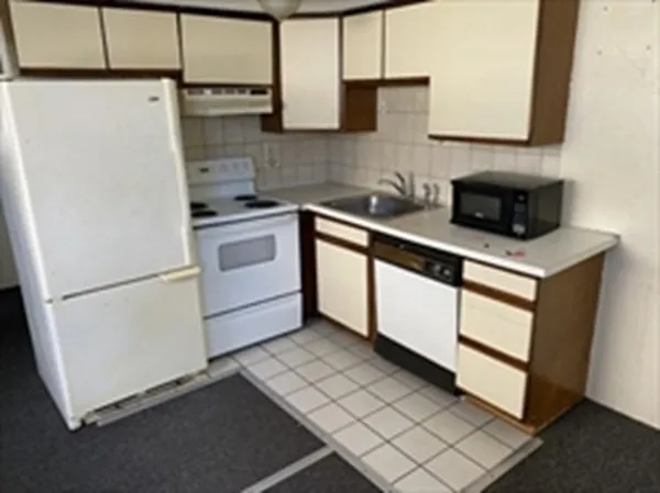a kitchen with a cabinets and white appliances