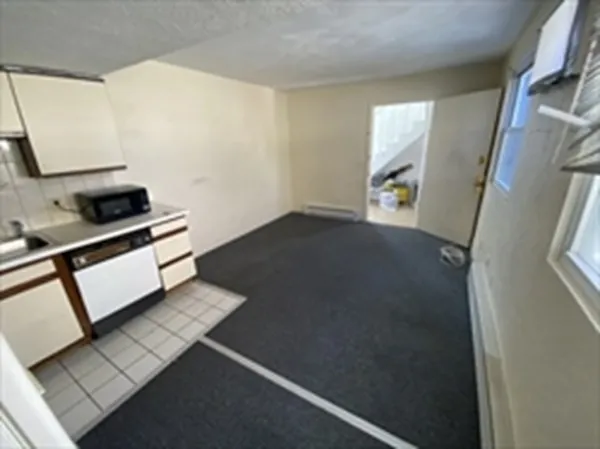 a kitchen with white cabinets and black appliances