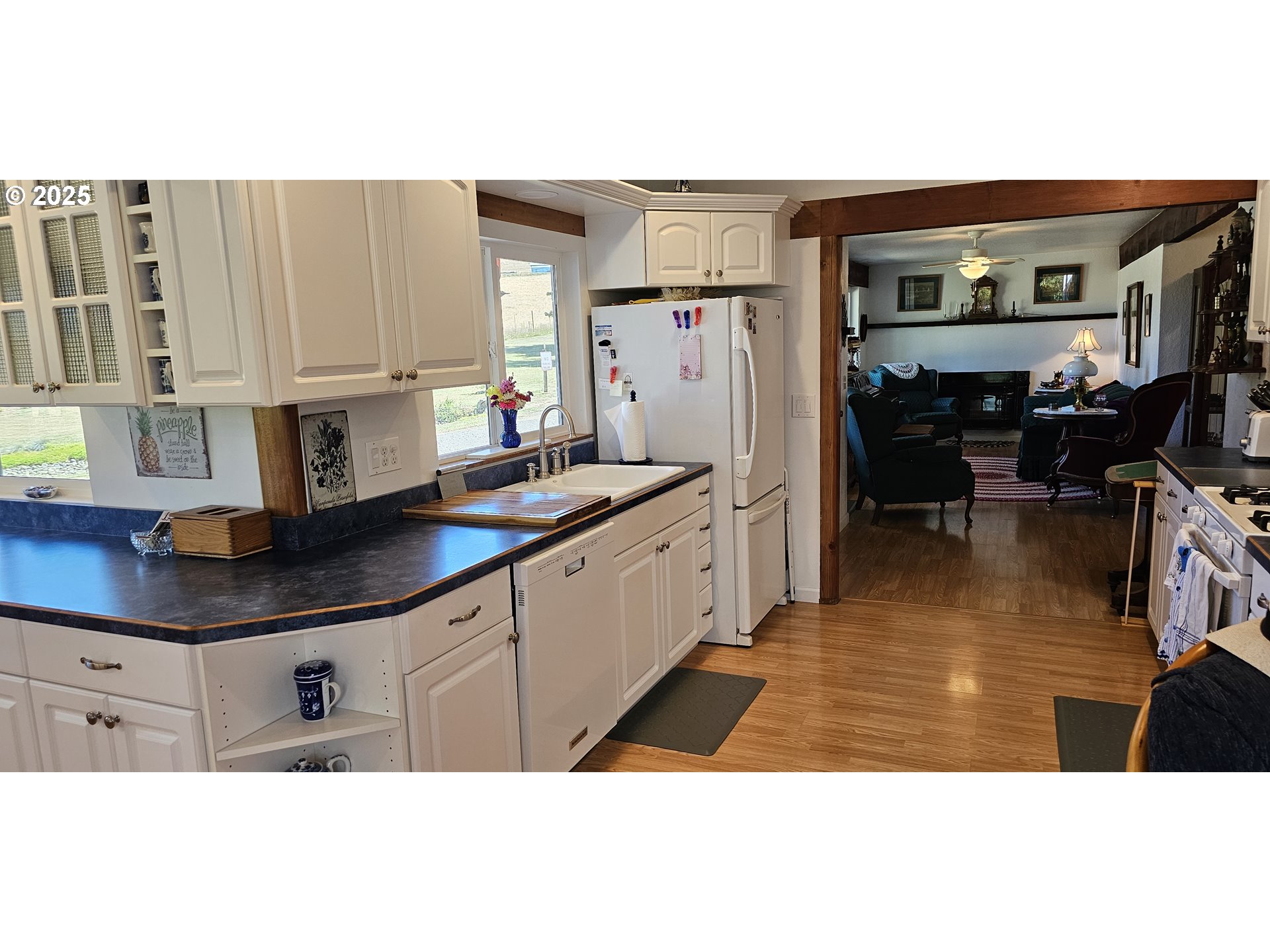 524 Azalea Drive Elkton, OR 97436 - Photo 16 of 48 a open kitchen with stainless steel appliances kitchen island granite countertop a refrigerator a oven a sink and white cabinets with wooden floor