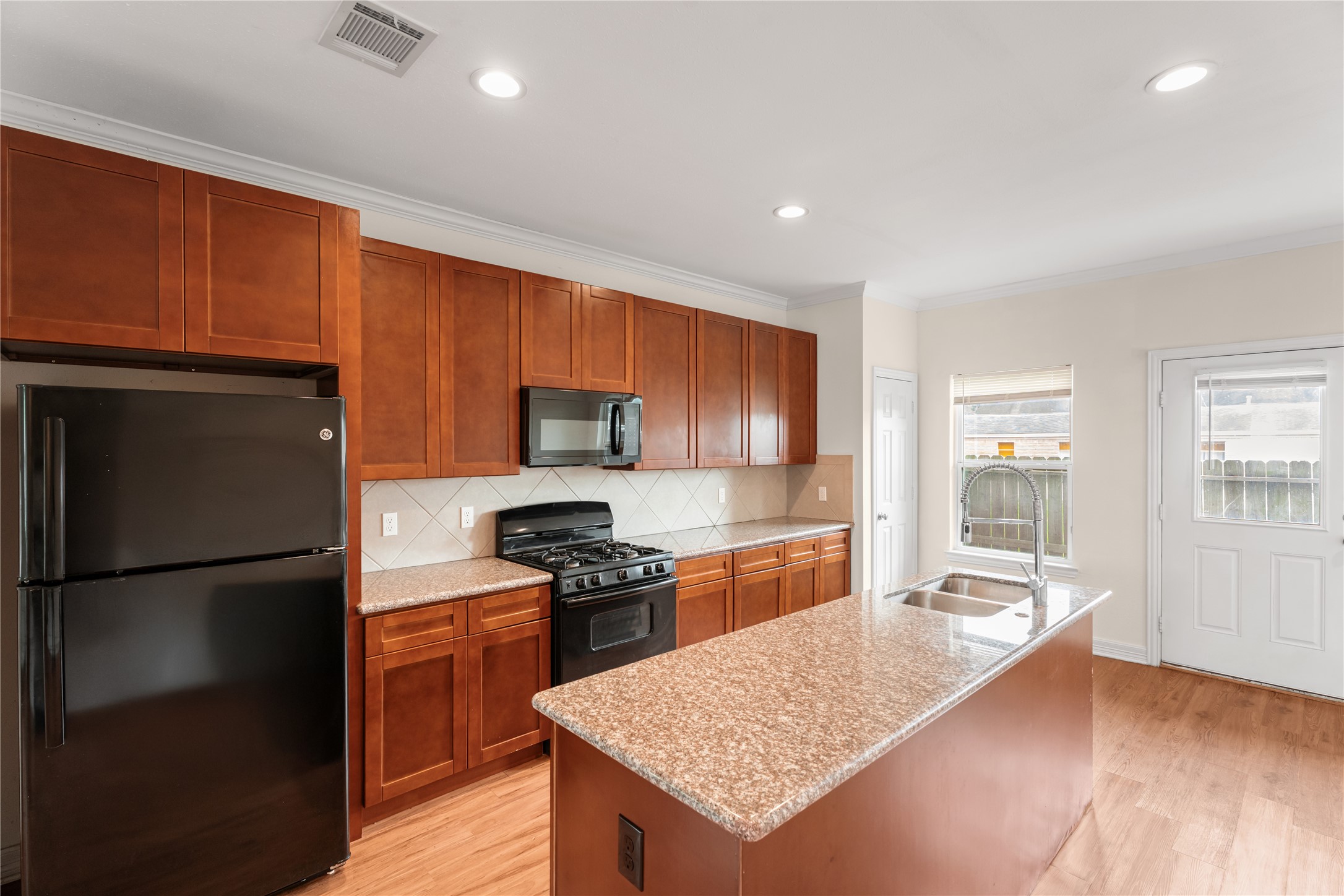 2407 Ferguson Way, Unit 1 Houston, TX 77088 - Photo 2 of 31 Spacious open-concept living room featuring luxury vinyl floors, abundant natural light, and a modern kitchen with island.