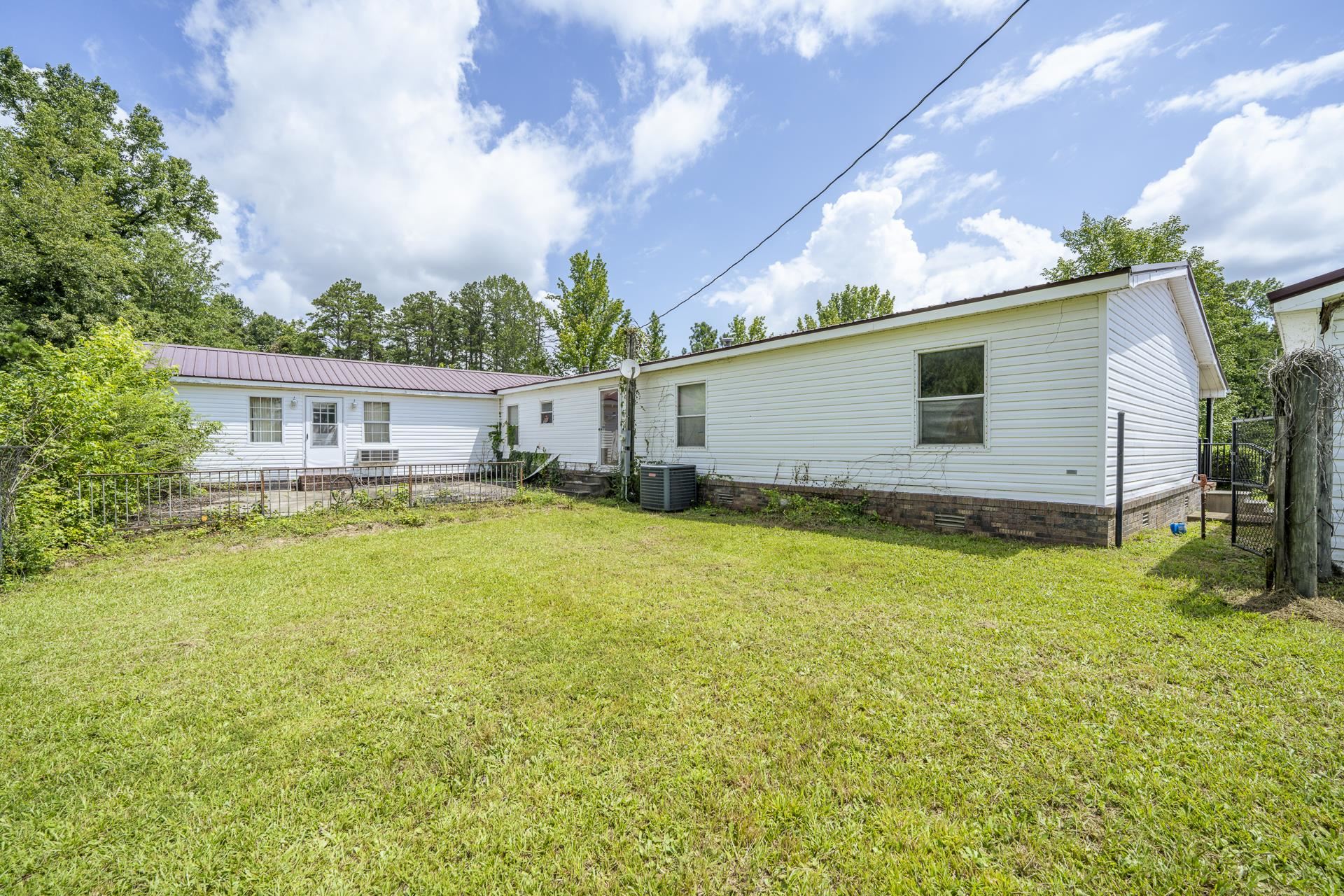 859 Old Morris Chapel Road Adamsville, TN 38310 - Photo 11 of 39 Spacious grassy yard with mature trees and a fenced boundary
