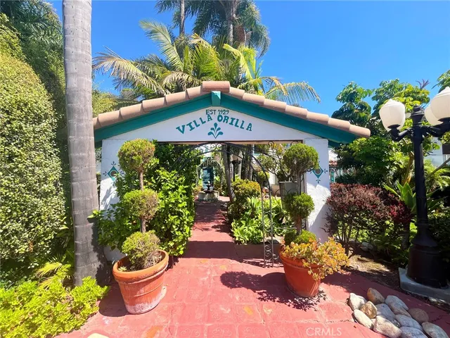 a front view of a multi story building with a lot of flower plants