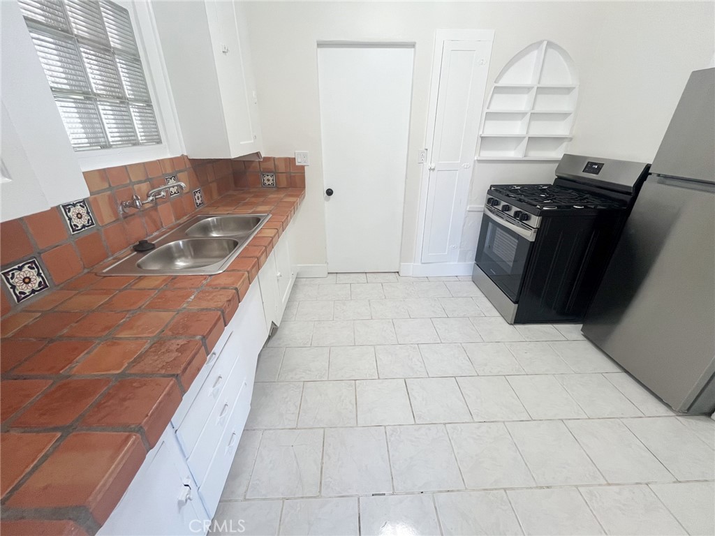 33910 Orilla Road, Unit 7 Dana Point, CA 92629 - Photo 12 of 50 a kitchen with granite countertop a stove a sink and a shower