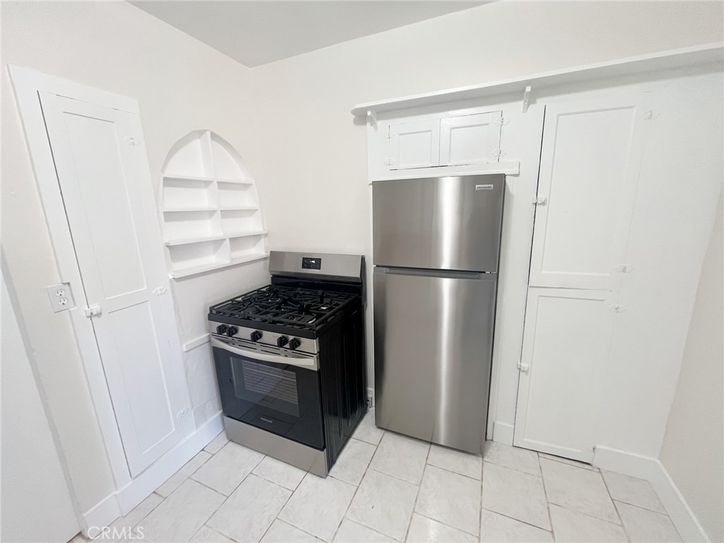 33910 Orilla Road, Unit 7 Dana Point, CA 92629 - Photo 15 of 50 a kitchen with a refrigerator a stove top oven and cabinets