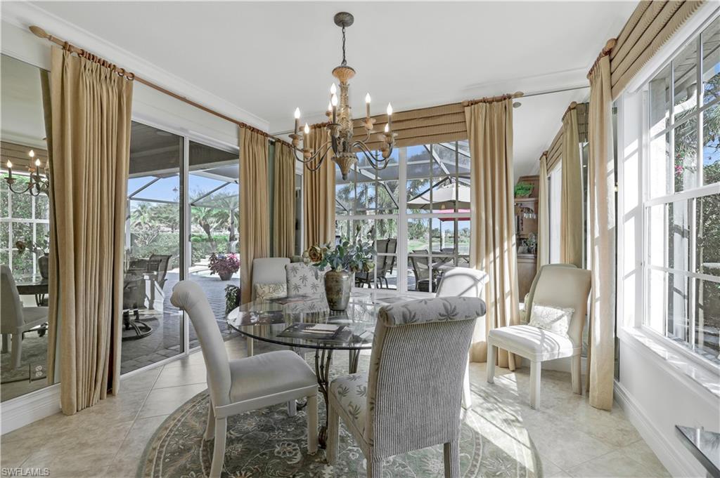 9104 Quartz Lane Naples, FL 34120 - Photo 18 of 47 a view of a dining room with furniture large windows and wooden floor