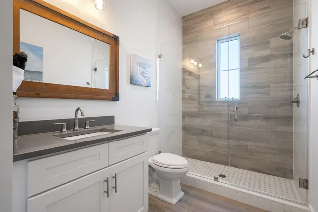 a bathroom with a sink a toilet and shower