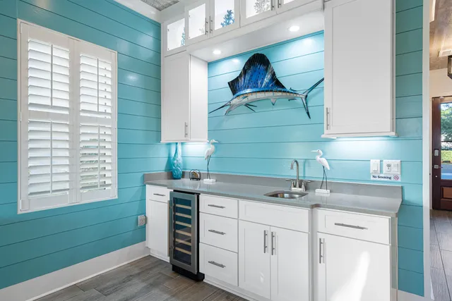 a kitchen with stainless steel appliances granite countertop a sink a stove a refrigerator cabinets and chairs