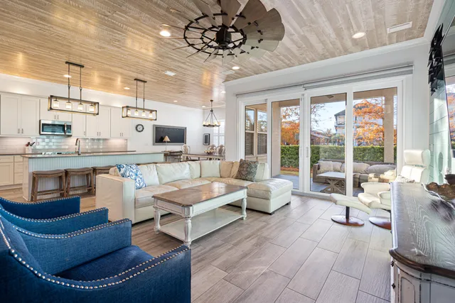 a view of a white house with a large tree