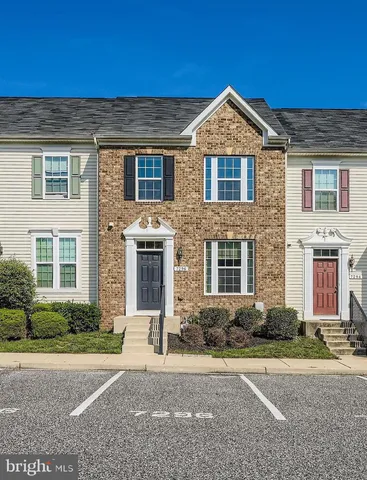 a front view of a house with yard and parking