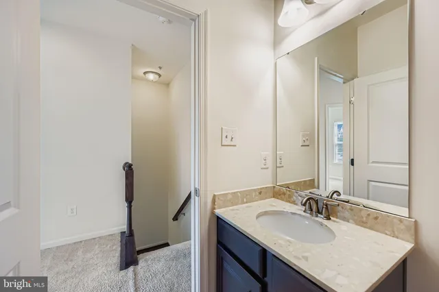 a bathroom with a sink vanity granite and a mirror
