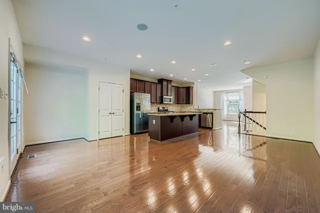 a view of kitchen with kitchen island sink refrigerator and white cabinets