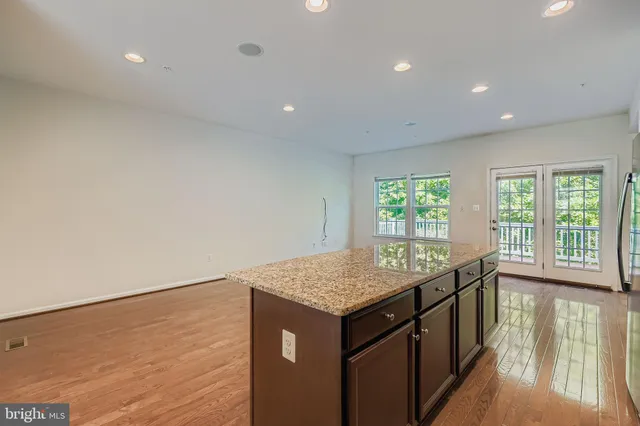 a kitchen with a sink a window and wooden floor
