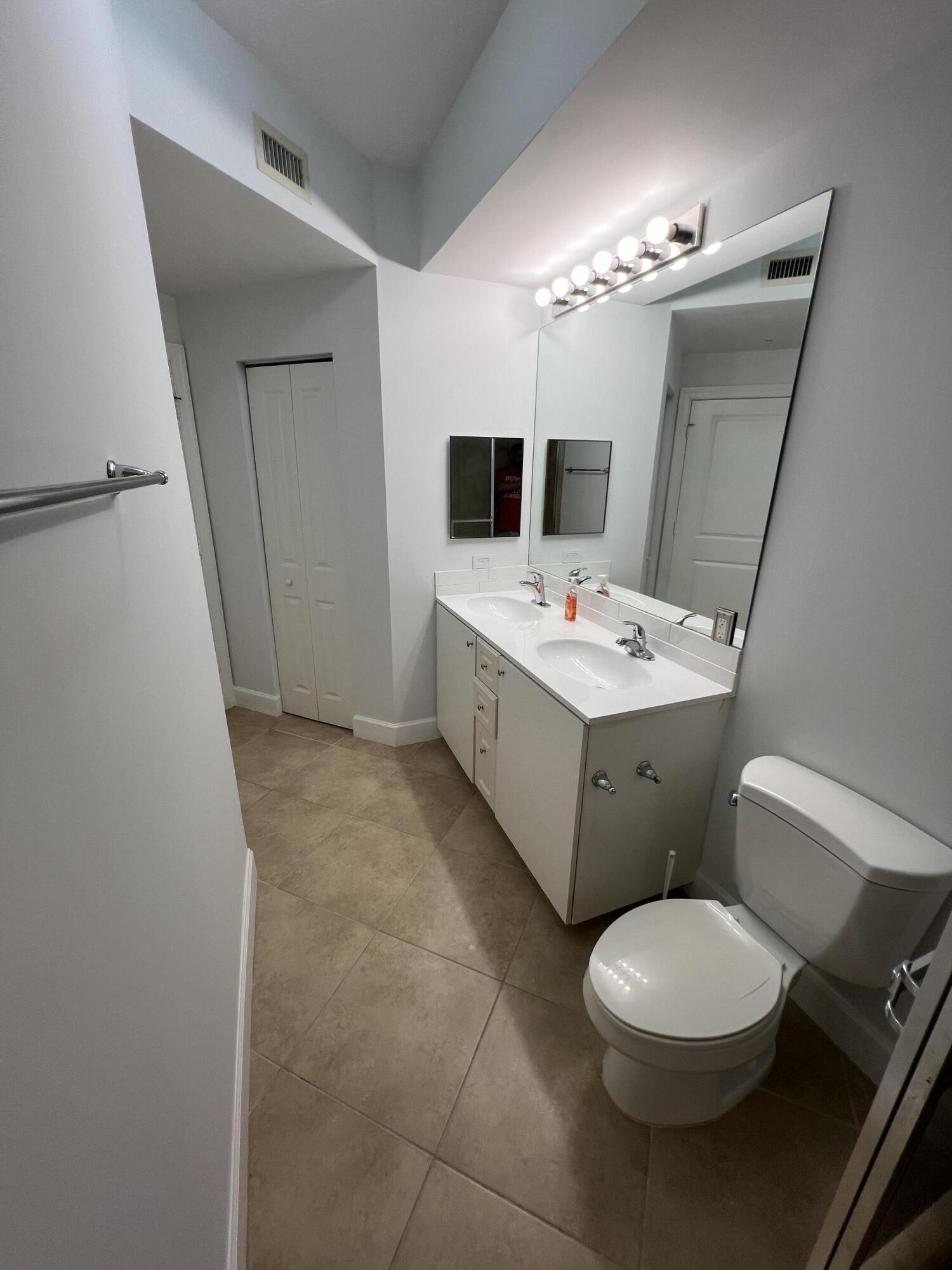 1660 Renaissance Commons Boulevard, Unit 2218 Boynton Beach, FL 33426 - Photo 11 of 23 a bathroom with a double vanity sink mirror and toilet