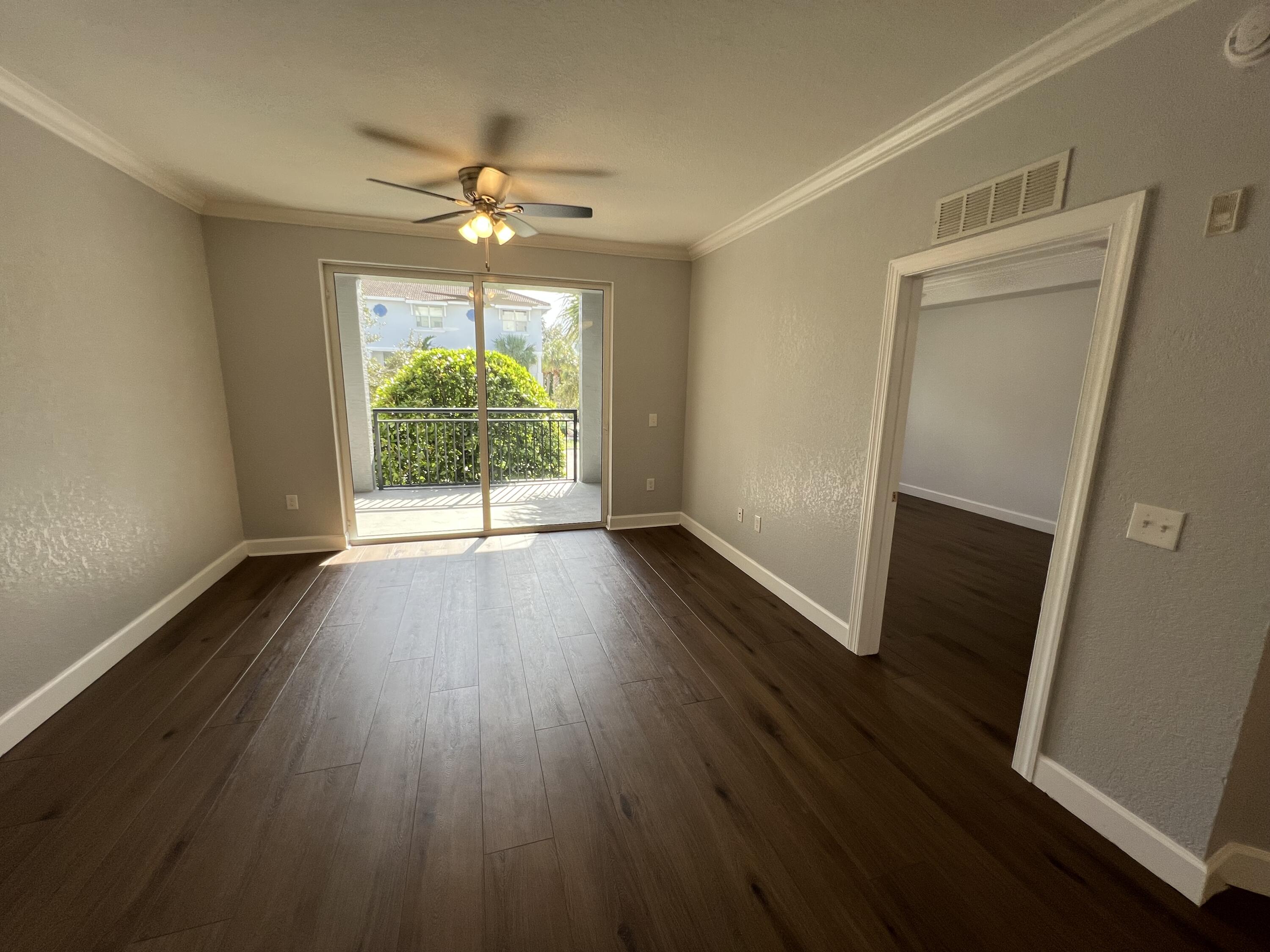 1660 Renaissance Commons Boulevard, Unit 2218 Boynton Beach, FL 33426 - Photo 13 of 23 an empty room with wooden floor and windows