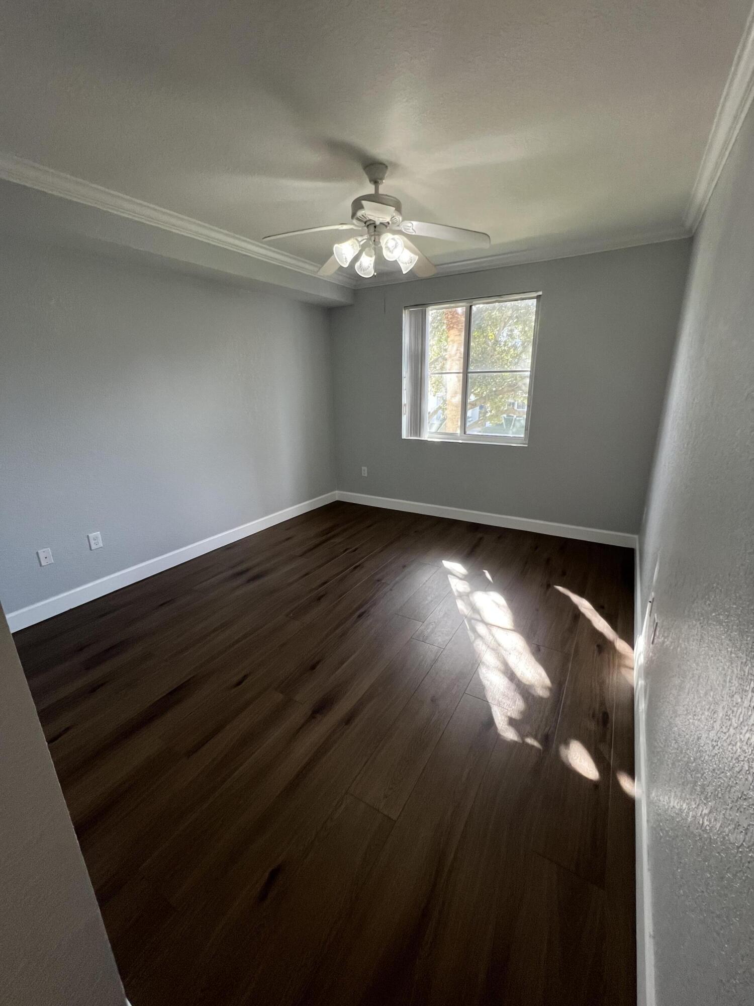 1660 Renaissance Commons Boulevard, Unit 2218 Boynton Beach, FL 33426 - Photo 15 of 23 wooden floor in an empty room with a window