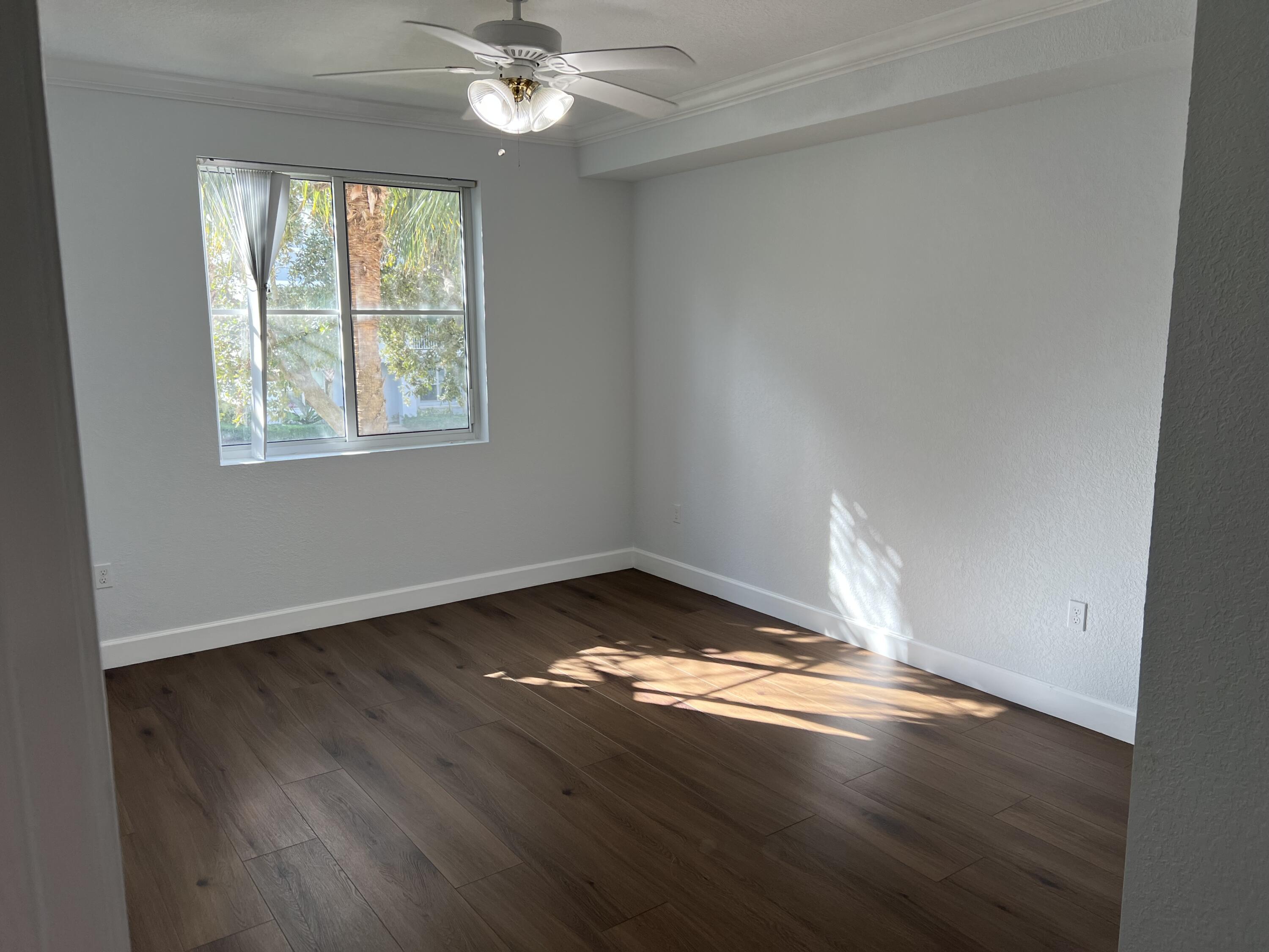 1660 Renaissance Commons Boulevard, Unit 2218 Boynton Beach, FL 33426 - Photo 8 of 23 an empty room with wooden floor and windows
