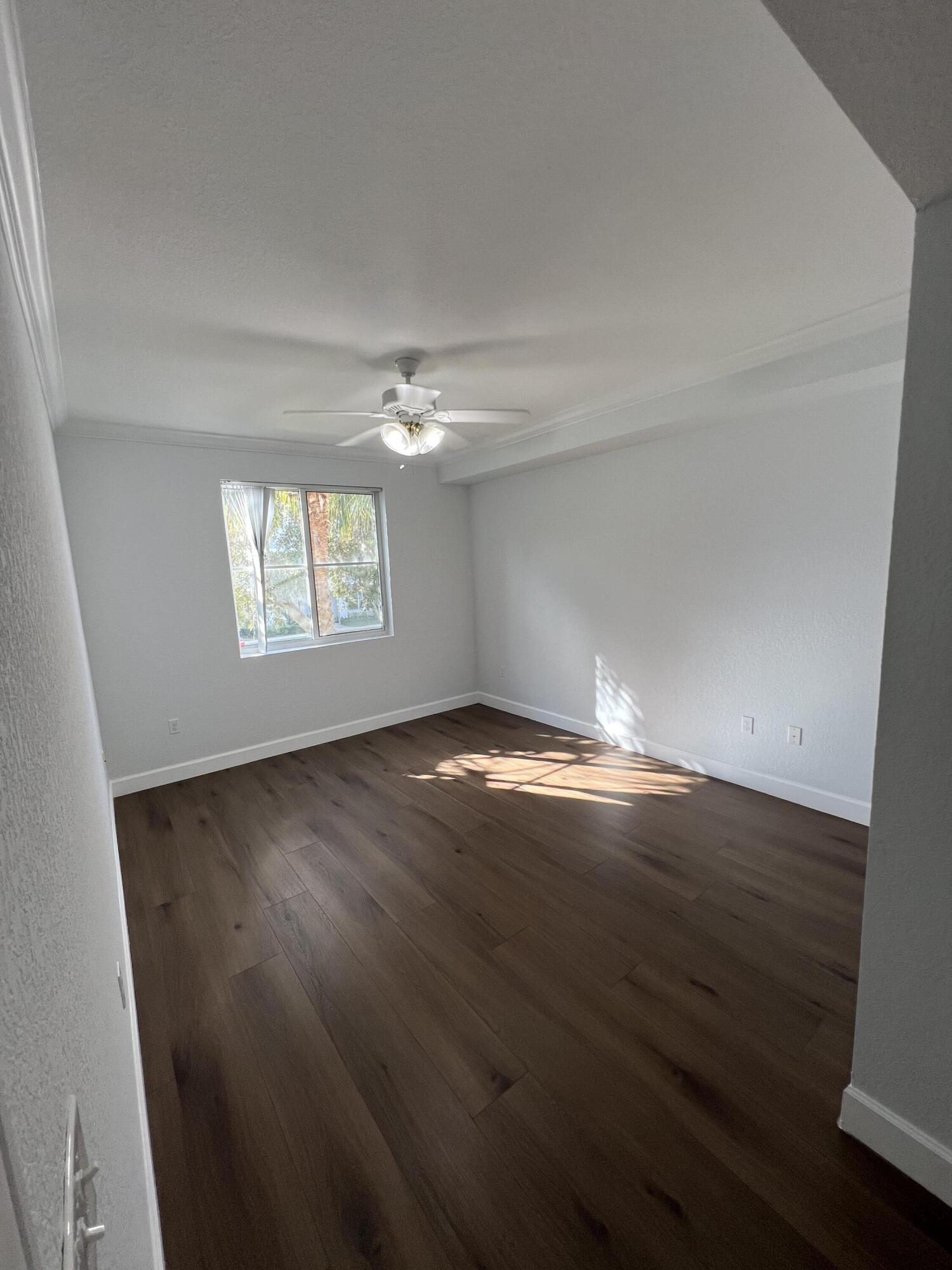 1660 Renaissance Commons Boulevard, Unit 2218 Boynton Beach, FL 33426 - Photo 9 of 23 an empty room with wooden floor and windows