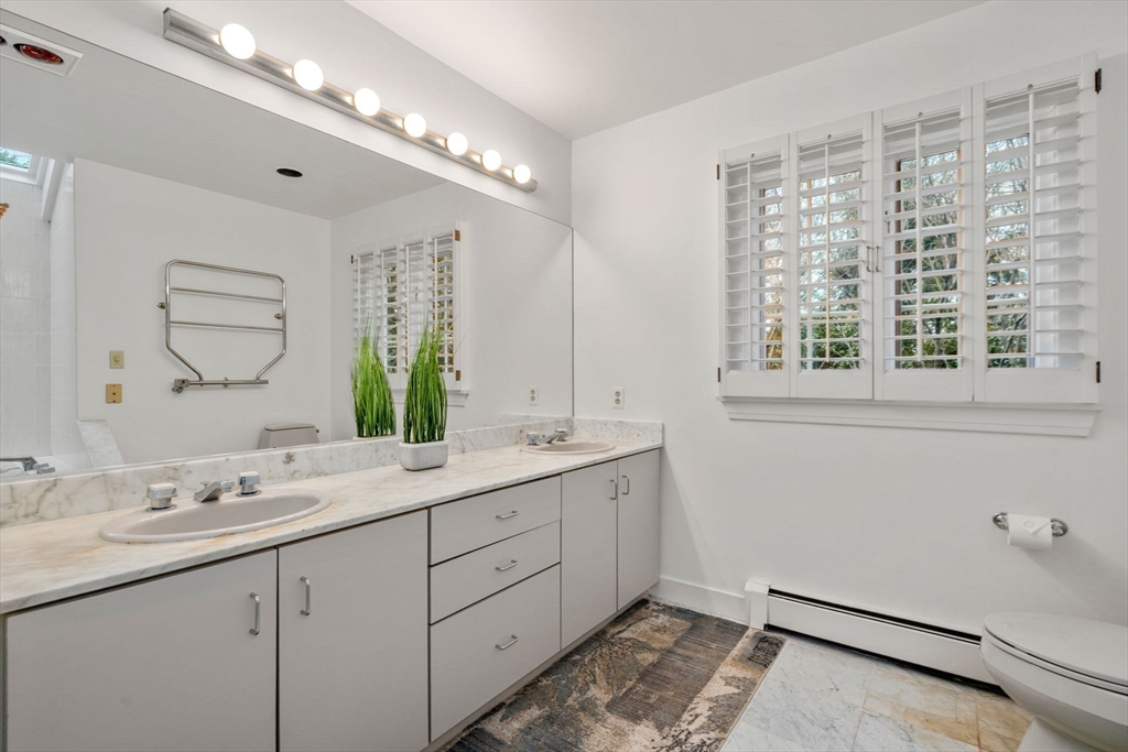26 Bullard Road Weston, MA 02493 - Photo 21 of 31 a bathroom with a double vanity sink a mirror and a shower