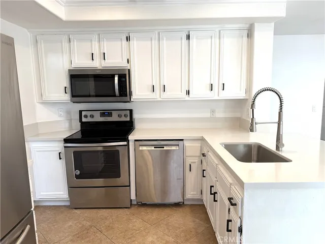 a kitchen with white cabinets and stainless steel appliances