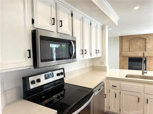 a kitchen with granite countertop white cabinets and white appliances