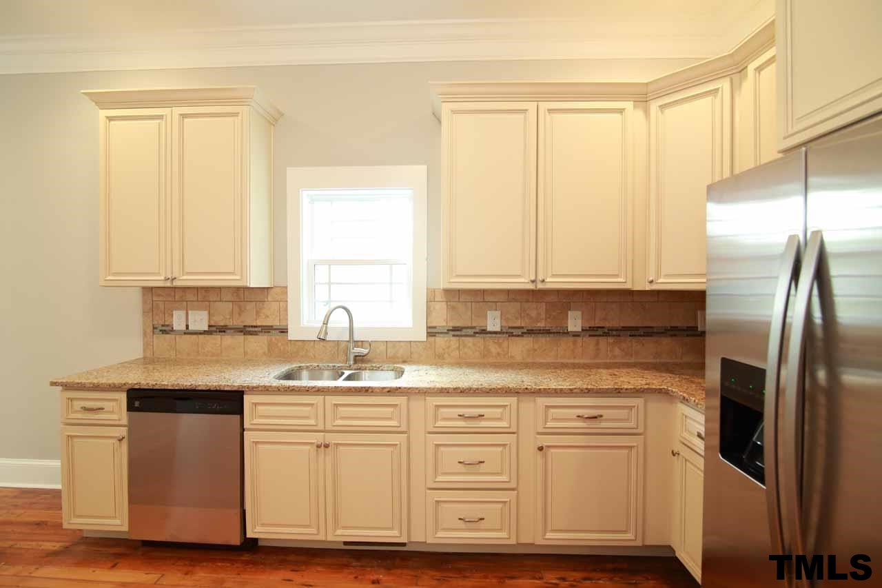 310 South State Street Raleigh, NC 27601 - Photo 8 of 25 a kitchen with stainless steel appliances granite countertop a sink a stove a refrigerator and island with wooden floor