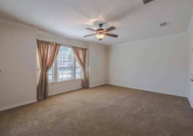 an empty room with windows and fan