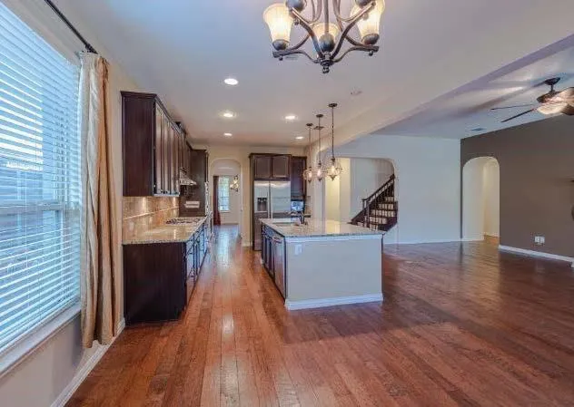 a view of a living room and kitchen with wooden floor and a large window