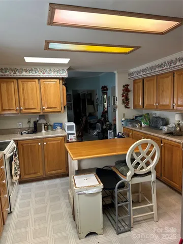 a view of a kitchen with kitchen island granite countertop a sink and a counter top space