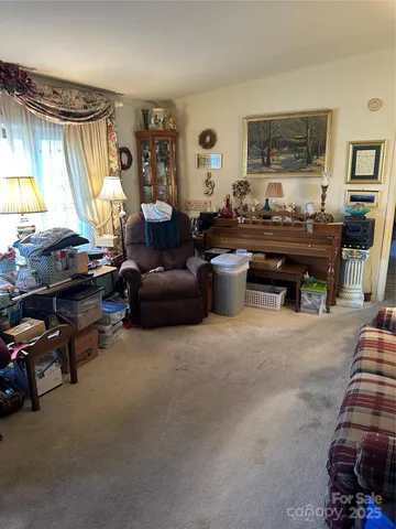 a living room with furniture a flat screen tv and a window