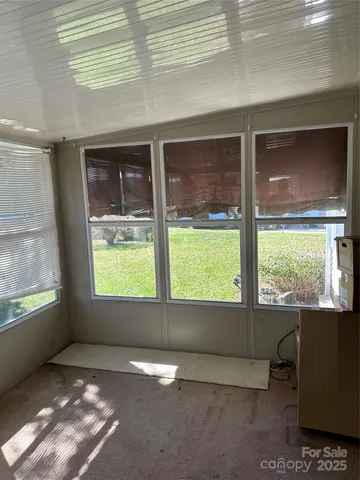 a view of a porch with chairs and backyard