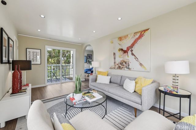 a living room with furniture a flat screen tv and a window