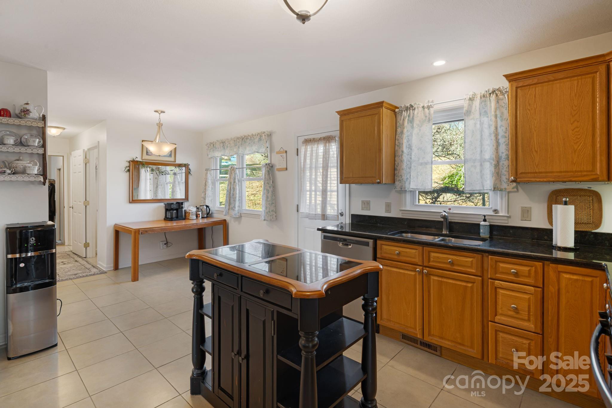154 Harris Street Spruce Pine, NC 28777 - Photo 13 of 37 a kitchen with granite countertop a sink stove and cabinets