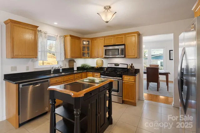 a kitchen with stainless steel appliances granite countertop a stove a sink a microwave and a refrigerator